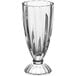 An Acopa clear glass dessert vase with a foot.