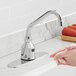 A person using a Waterloo deck mount hands-free sensor faucet with a surgical bend gooseneck spout to wash their hands.