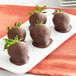 A plate of chocolate covered strawberries with Ghirardelli 100% Cacao Unsweetened Chocolate Liquor Wafers.