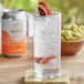 A glass of DayPack Blood Orange Non-Alcoholic Sparkling Hop Water with a slice of orange in it.