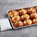 A tray of Dutch Country Foods soft pretzel knot rolls on a counter.