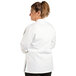 A woman wearing a white Uncommon Chef Sedona long sleeve chef coat.