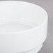 A close up of an Arcoroc white porcelain bowl with a white rim.