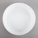 An Arcoroc white porcelain bowl on a gray surface.