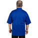 A man wearing a Uncommon Chef Venture Pro short sleeve chef coat in deep royal blue with mesh back.