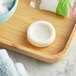 A piece of Nourish grapefruit bar soap on a wooden tray.
