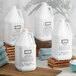 A group of white jugs of Beekman 1802 Fresh Air Body Wash on a wooden shelf.
