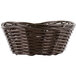 A close-up of a brown oval rattan basket with handles.