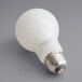 A TCP frosted LED filament light bulb with a label on a grey background.