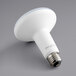 A TCP Elite 9.5W dimmable LED light bulb with a white surface.