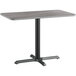 A Lancaster Table & Seating rectangular table with a black base and reversible gray and white laminated top.