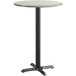A white and gray round table top on a black pole with a black base.