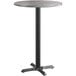 A round bar height table with a Lancaster Table & Seating black base and reversible grey and white laminated top.