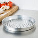 An American Metalcraft silver metal pizza pan with holes in it.