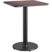 A Lancaster Table & Seating table with a black metal base and a metal pole.