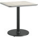 A square table with a black base and a reversible gray and white laminated top.