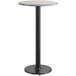 A round gray and white laminated table top with a black metal pole base.