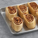 A tray of Orange Bakery Danish Cinnamon Rolls with icing on top.