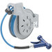 A close-up of a T&S blue epoxy-coated steel hose reel with a hose attached.