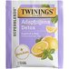 A purple and white Twinings Detox Adaptogens tea package with a slice of grapefruit and basil on a white background.