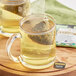 A glass mug with a Twinings Pure Sencha Green tea bag in it.