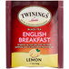 A red and white box of Twinings English Breakfast tea bags with text and a lemon.