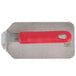 A metal steak weight with a red silicone handle.
