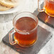 Two glass mugs of Twinings Chai Tea on a stone coaster.