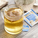 A glass mug of Twinings Superblends Sleep+ Chamomile, Cinnamon & Vanilla tea with a tea bag in it.