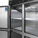 A Turbo Air stainless steel reach-in refrigerator with open half doors showing shelves and a vent.
