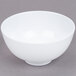 A white GET Water Lily melamine bowl with a white rim on a gray surface.