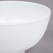 A close-up of a white GET Water Lily melamine bowl with a white rim.