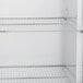 A Traulsen white reach-in refrigerator with metal shelves.