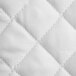 A close up of a white Oxford Super Blend quilted bed topper with a diamond check pattern.
