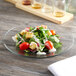 A salad on an Anchor Hocking glass plate with a fork.