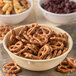 A Carlisle tan melamine nappie bowl filled with pretzels and other snacks.