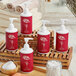A group of red and white Noble Eco Novo Natura lotion bottles with white caps on a wooden tray.