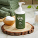 A green bottle of Noble Eco Novo Terra conditioning shampoo with a white cap on a wood slice.