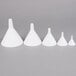 A set of five white cone shaped funnels.