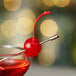 A close-up of a red cocktail with a Regal Maraschino cherry on top.