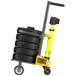 A yellow and black hand truck with a stack of Banner Stakes weights.