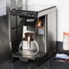 A Bunn SmartWAVE airpot coffee brewer on a counter in a corporate office cafeteria.