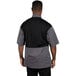 A man wearing a Uncommon Chef Rogue Pro Vent chef coat with a grey and black mesh back.