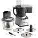 A Waring commercial food processor with a clear bowl, continuous feed attachment, and discs.