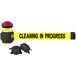A yellow Banner Stakes wall mount belt barrier with black text reading "Cleaning in Progress" and two red lights.