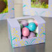 A white Easter egg candy box with a window holding a blue egg.