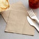 A fork and knife next to a Natural Kraft EcoChoice luncheon napkin.