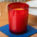 A red Cambro plastic tumbler with a red liquid inside on a table