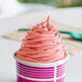 A pink cup of Dannon YoCream frozen yogurt with a scoop on top.