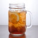 A Libbey mason jar filled with iced tea and a lemon slice.